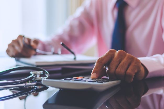 Smart doctor hand using calculator 